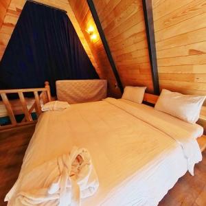 a large white bed in a room with wooden walls at Sapanca Sudere Bungalov 2 in Sakarya