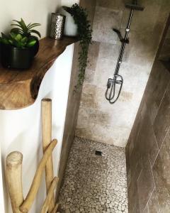 La salle de bains est pourvue d'une douche et d'un sol en pierre. dans l'établissement Le Loys Martinique, à Sainte-Anne