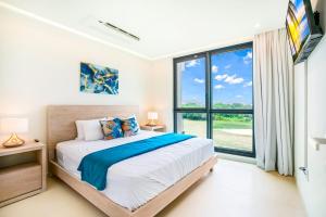 una camera da letto con un letto e una grande finestra di Luxury Oceanview 1BR on beach a Cupecoy Altre 36 foto