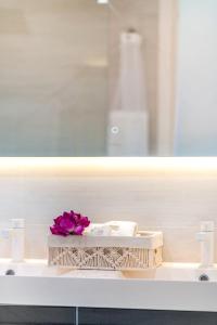 un lavandino in bagno con un fiore rosa di Luxury Oceanview 1BR on beach a Cupecoy