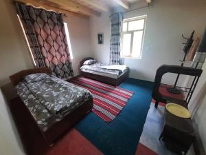 a living room with two beds and a window at Jumaboy Guesthouse 