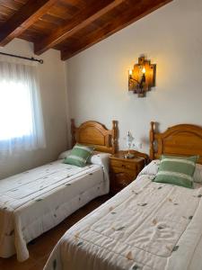 a bedroom with two beds and a window at Casa Rural El Aljibe in San Agustín