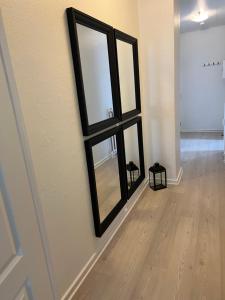 a mirror on a wall in a room with a wooden floor at Lille Vedelsborg in Vejle