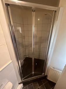 um chuveiro com uma porta de vidro na casa de banho em Moor Park Apartments em Preston
