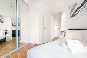 sypialnia z białym łóżkiem i lustrem w obiekcie Lovely one bedroom in the heart of London w Londynie