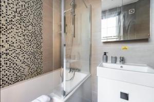 W łazience znajduje się prysznic i umywalka. w obiekcie Lovely one bedroom in the heart of London w Londynie