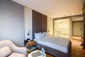 a hotel room with a bed and a couch at Yacht Hotel in Vlorë