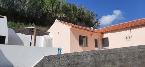 an umbrella sitting on a wall next to a building at Cantinho da Ribeira in Castelo Branco