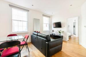 a living room with a couch and a table with chairs at stylish flat in heart of London in London