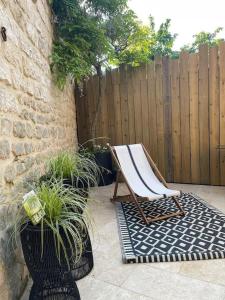 a chair sitting on a patio next to a fence at Maison en centre ville avec extérieur in Compiègne