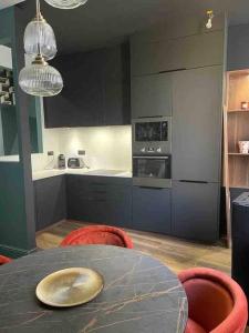 une cuisine avec une table et des chaises rouges et une cuisine avec une cuisinière dans l'établissement Maison en centre ville avec extérieur, à Compiègne