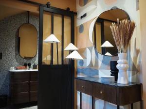 La salle de bains est pourvue de deux miroirs et d'un comptoir avec un lavabo. dans l'établissement Maison en centre ville avec extérieur, à Compiègne 4 autres photos