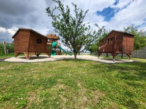 einen Spielplatz mit einem Baum und einer Rutsche in der Unterkunft Chalupa Oslany in Oslany