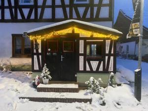 a house with lights on it in the snow at Ferien auf dem Eliesenhof in Welzheim