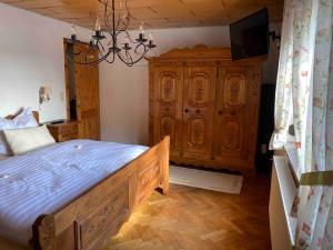 a bedroom with a bed and a large wooden cabinet at Ferien auf dem Eliesenhof in Welzheim