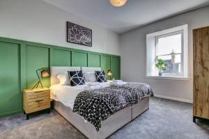 a bedroom with a bed and a green wall at The Irvine - Coorie Doon Apartments in Irvine