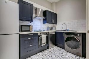 a kitchen with a washing machine and a microwave at The Irvine - Coorie Doon Apartments in Irvine