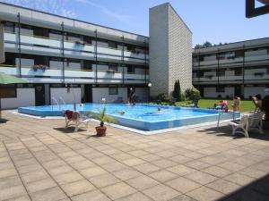 a large swimming pool in front of a building at Möhnestube mit Seeblick, Pool und Sauna in Möhnesee