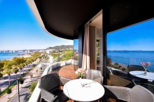 a balcony with tables and chairs and a view of the ocean at Yacht Hotel in Vlorë