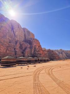 Star City Camp wadirum في وادي رم: صحراء مع جبل في الخلفية