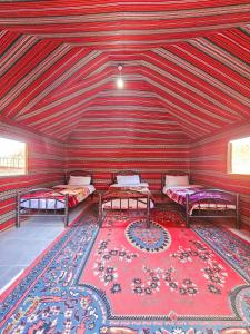 a room with two beds and a rug at Star City Camp wadirum in Wadi Rum +127 photos