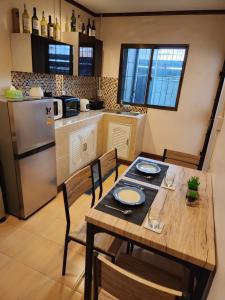 eine Küche mit einem Holztisch mit Stühlen und einem Kühlschrank in der Unterkunft The Travellers House - Pet Friendly Accommodation in Bangkok
