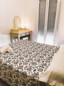 - une chambre avec un lit et une couverture noire et blanche dans l'établissement Apartamentos Bollullos, à Bollullos de la Mitación