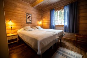 a bedroom with a bed in a wooden cabin at Lomavouti Cottages in Savonranta