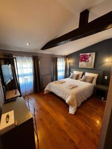 a bedroom with a large bed and a flat screen tv at Les Remparts in Mirepoix