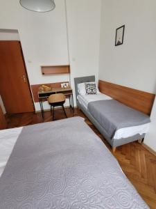 Habitación con 2 camas, mesa y escritorio. en Zajazd Meran, en Krynica-Zdrój