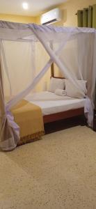 a bed with a canopy in a room at Bella Breeze2 -Diani Beach Kenya in Diani Beach