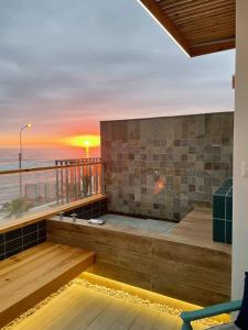 a balcony with a view of the ocean at sunset at Kauhuhu Casa Hotel in San Bartolo