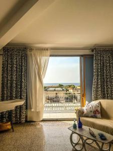 a living room with a couch and a large window at Casetta della Muri in Isola delle Femmine