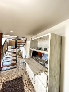 a kitchen with white cabinets and a staircase at Casetta della Muri in Isola delle Femmine