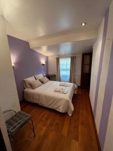 a bedroom with a large white bed and a window at Les Remparts in Mirepoix