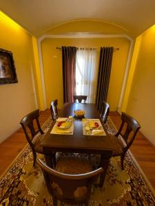 a dining room with a wooden table and chairs at Bora Hotel in Gjirokastër