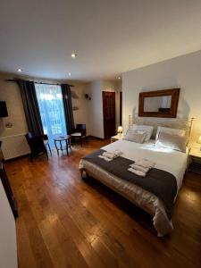 um quarto grande com uma cama grande e pisos em madeira em Les Remparts em Mirepoix