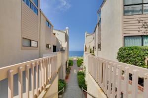 a pathway between two buildings with the ocean in the background at Stunning Solana Beach Condo with Community Pools! in Solana Beach