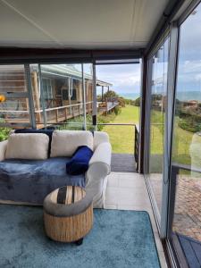 ein Wohnzimmer mit einem Sofa und einem Tisch in der Unterkunft Rocky Bay on the View in Gordonʼs Bay