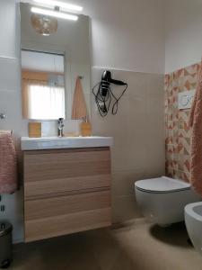 a bathroom with a sink and a toilet and a mirror at Raggio di Sole in Gaeta