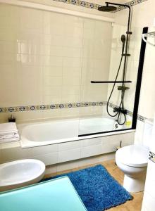 La salle de bains est pourvue d'une baignoire, de toilettes et d'un lavabo. dans l'établissement Apartment VillaMartin Plaza - The Loft, à Orihuela Costa
