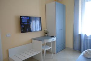 1 dormitorio con escritorio y TV en la pared en Raggio di Sole, en Gaeta