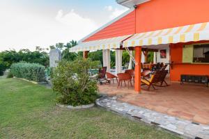 a patio with chairs and tables on a house at Villa Devaki in Saint-François