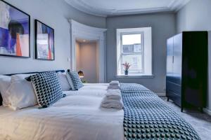 a large white bed in a room with a window at The Annick - Coorie Doon Apartments in Irvine