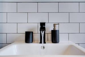 a sink with two cups and a faucet on it at The Annick - Coorie Doon Apartments in Irvine