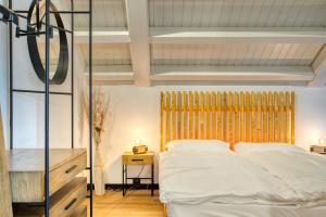 1 dormitorio con 1 cama con sábanas blancas en Alaïa Lodge, en Crans-Montana