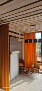 een woonkamer met oranje gordijnen en een tafel bij WILLA VASCO BOSMAN in Rewa