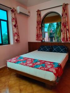 - une chambre avec un lit et un miroir dans l'établissement Villa Cleto Guest House, à Panaji
