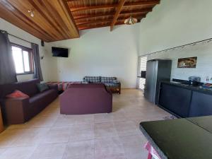a living room with a couch and a refrigerator at Casa de Praia da Ju - Caraguatatuba in Caraguatatuba