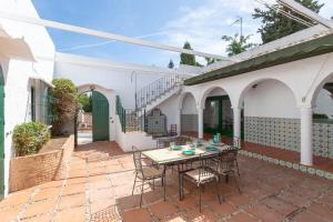 a patio with a table and chairs in a house at Villa Los Tres Almendros in Marbella